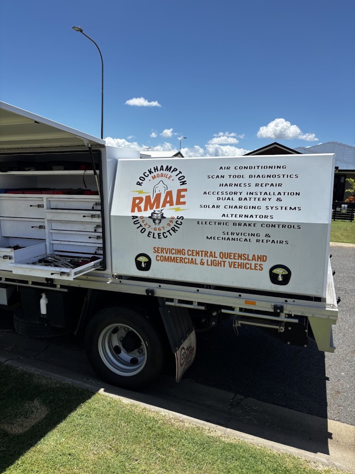 The RMAE mobile service ute with its canopy lifted and tool drawers pulled out, the service list printed along the side